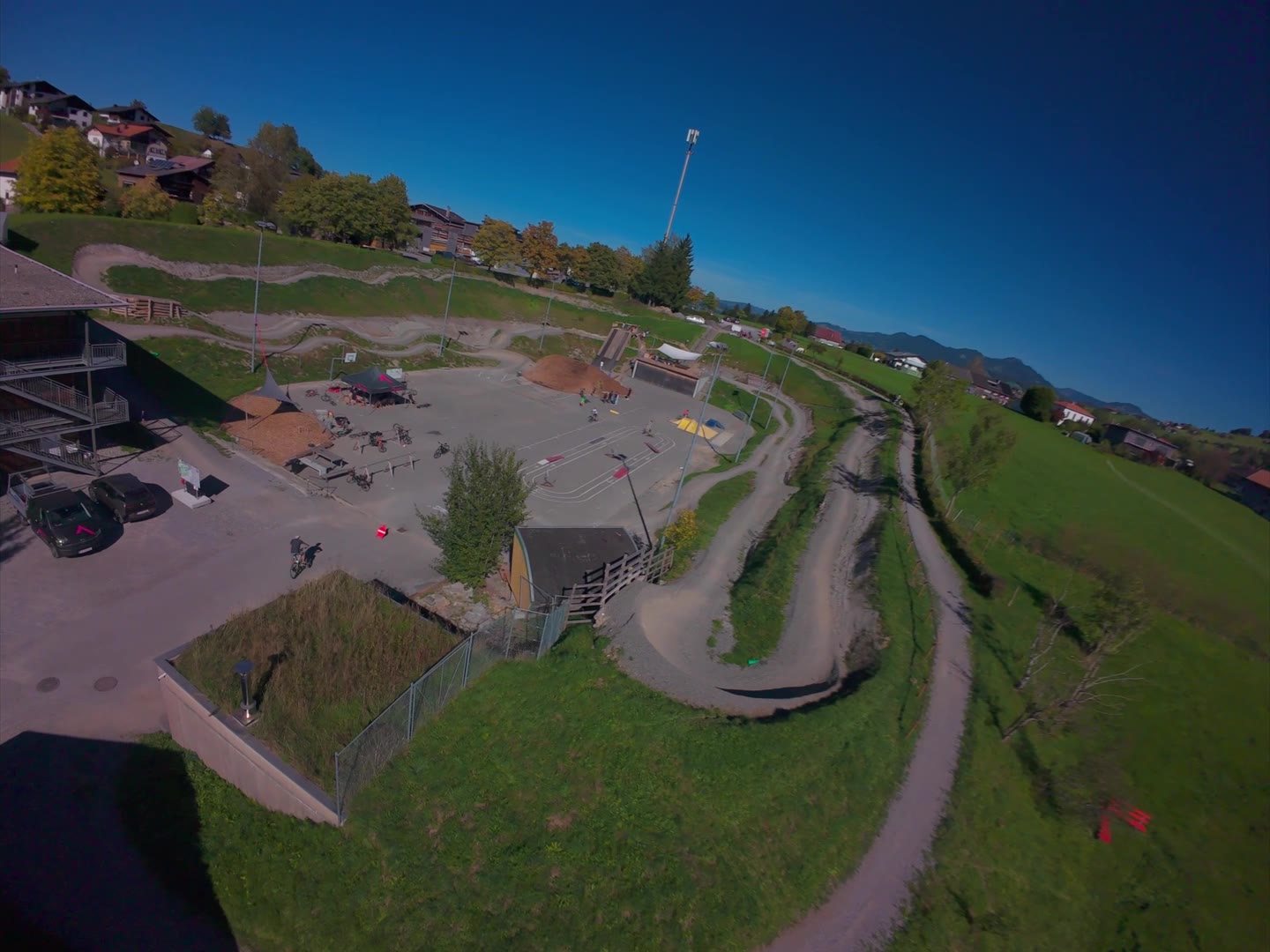 Luftaufnahme der Bikepark Arena Alberschwende mit Pumptrack, Trails und Wiesen im Herbstlicht